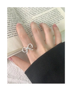 Detail view of a S925 sterling silver hollow bow ring with polished finish on model
