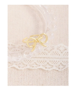 Detailed shot of a gold-plated bow ring with a polished finish and adjustable band