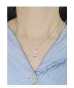 Gros plan du collier double rang en argent S925 avec pendentifs cerises sur modèle