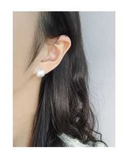 Detail of S925 sterling silver ball stud earring with brushed matte finish on ear