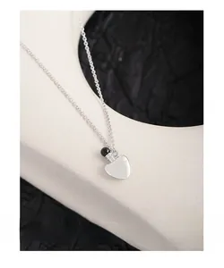 Detail of S925 silver necklace featuring a black agate bead and heart-shaped pendant