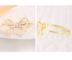 Detail of S925 silver gold-plated ring featuring pearl bow and square zircon stone
