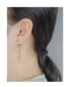 Detailed view of silver asymmetric drop earrings with elegant chain tassels and bead detail
