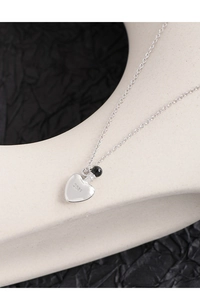 Macro shot of S925 sterling silver perfume bottle heart necklace with black agate bead