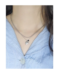 Detail of layered S925 silver necklace featuring a heart pendant and black agate bead