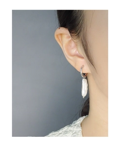 Close-up of S925 silver hoop earring with asymmetric baroque pearl on female model