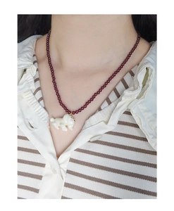 Close-up of S925 silver necklace with red beads and a cute white puppy charm