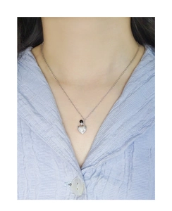 Detail view of a 925 sterling silver heart necklace with a black agate bead on a model