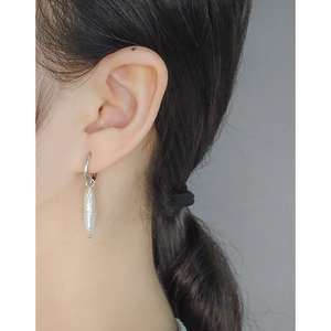 Baroque pearl drop earrings with polished silver hoops worn for an elegant minimalist look