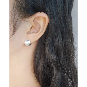 Elegant S925 sterling silver brushed ball earrings worn on ear for a minimalist look