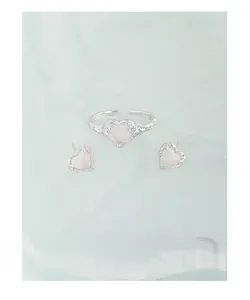 Macro detail of S925 silver heart ring and studs set with textured stone finish