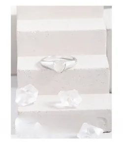 Détail de la bague en argent S925 avec agate blanche sur un support en pierre