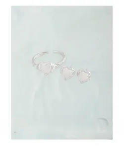 Detail of S925 silver heart jewelry set with white agate stones on teal background