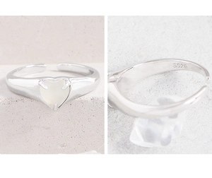 Détail d'une bague en argent S925 avec pierre blanche en forme de cœur et poinçon gravé