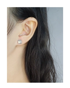 Close-up of S925 silver square stud earring with grey translucent stone on model