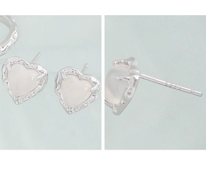 Detail of S925 sterling silver heart earrings featuring irregular texture and stamp