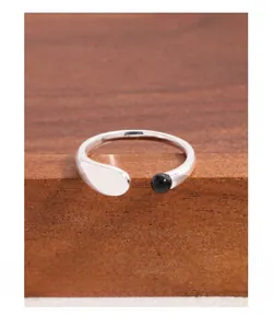 Close-up of S925 sterling silver U-shape ring with black agate bead on wood display