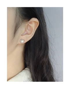 Close-up of S925 silver heart stud earrings with texture details on model's ear