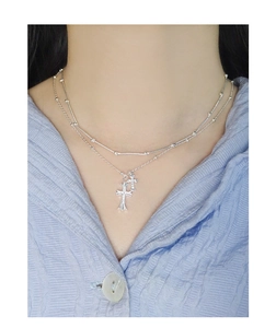 Detail of double-layered silver S925 necklace featuring cross pendants and bead accents