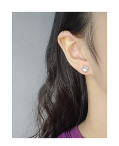 Macro detail of silver milgrain square stud earrings with milky white gemstone inlay