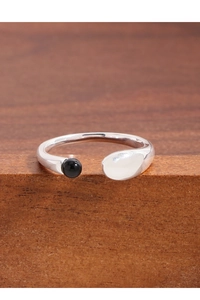 Detailed view of S925 silver U-shape ring with black onyx bead on wood surface