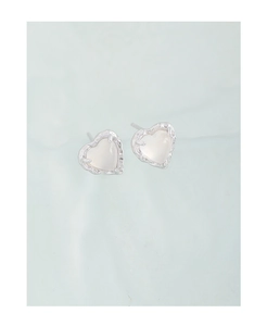 Detail of silver heart earrings with white agate stone and textured metal frame