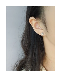 Detail of S925 silver heart earring with textured edge and iridescent shell inlay
