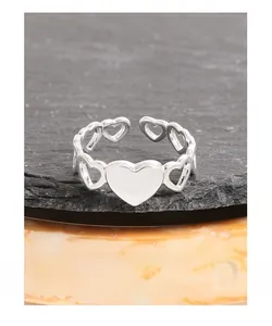 Detail of S925 silver heart ring with solid and hollow motifs on grey stone