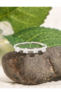 Macro detail of silver heart-shaped adjustable open ring on a natural stone surface