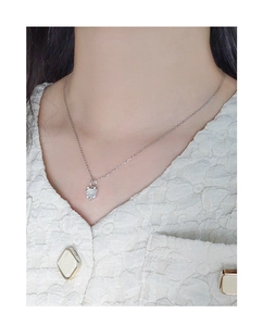 Detail of silver S925 heart pendant necklace with white opal stone on woman's neck