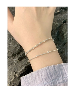Détail de bracelets superposés en argent S925 avec maillons bambou et design corde torsadée