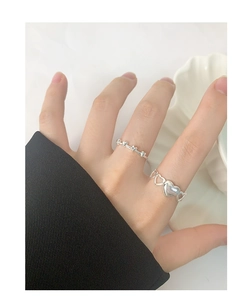 Detail of S925 sterling silver heart ring set worn on finger with minimalist design