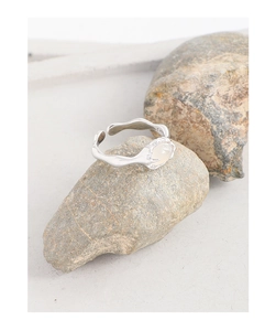 Macro detail of S925 silver rippled ring featuring a white oval agate stone inlay