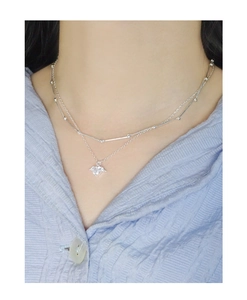 Close-up of double-layered silver bamboo link necklace with winged heart zircon pendant