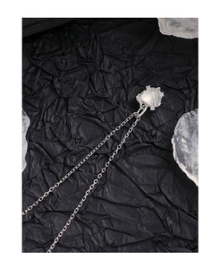 Macro view of textured silver heart pendant with moonstone and zircon on black background