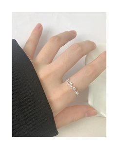 Close-up of minimalist S925 sterling silver ring with continuous small heart pattern
