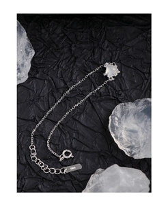 Détail macro de la chaîne en argent 925 avec pendentif cœur en agate translucide et fermoir