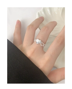 Macro shot of S925 sterling silver heart-shaped ring worn on finger with shell decor