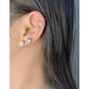 Set of minimalist S925 sterling silver studs with heart and oval shapes on model's ear
