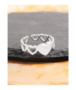 Close-up of S925 silver ring featuring hollow and solid heart shapes on stone
