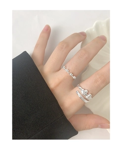 Close-up of S925 sterling silver heart rings on hand with a white ceramic background