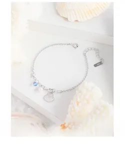 Detail of S925 sterling silver bracelet with shell charm, white pearl and blue crystal