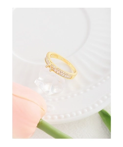 Détail d'une bague nœud en argent S925 doré avec zircons sur un fond décoratif élégant