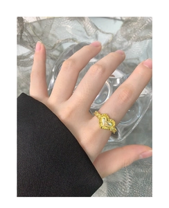 Close-up of golden S925 sterling silver heart ring with pleated texture on model finger