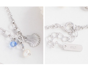 Detail view of S925 sterling silver bracelet with shell, blue bead and pearl charms
