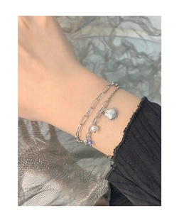 S925 silver double-layer bracelet with shell, pearl, and purple stone on a model's wrist