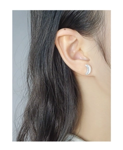 Silver crescent moon stud earrings shown on ear for actual size and style reference