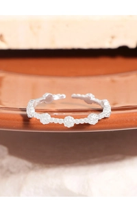 Dettaglio dell'anello aperto a sfere in argento S925 con piccoli fiori delicati