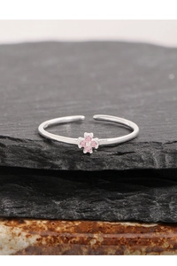 Vue macro d'une bague fleur en argent S925 avec zircons roses sur pierre noire