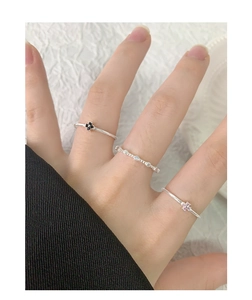 Détail de trois bagues minimalistes en argent S925 avec fleurs et zircons